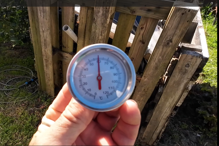 Heating water using the heat generated by microbes breaking down compost material